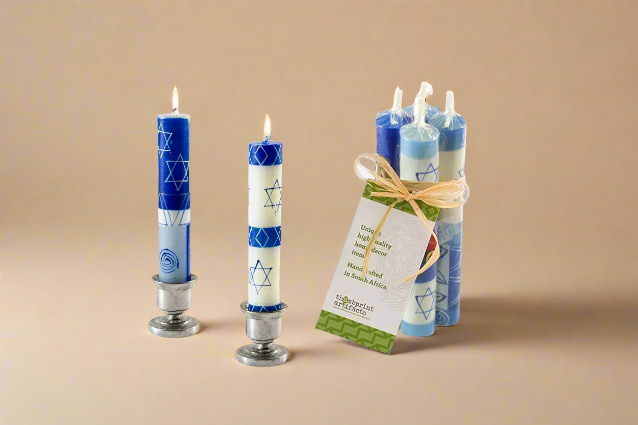 Set of blue and white candles with Star of David design on a beige background